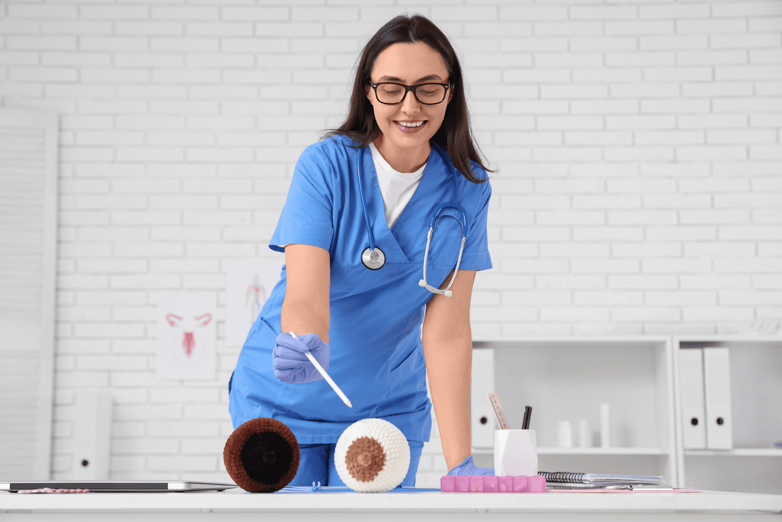 Healthcare professional demonstrating breast care using a breast model to explain how to prevent clogged milk ducts.