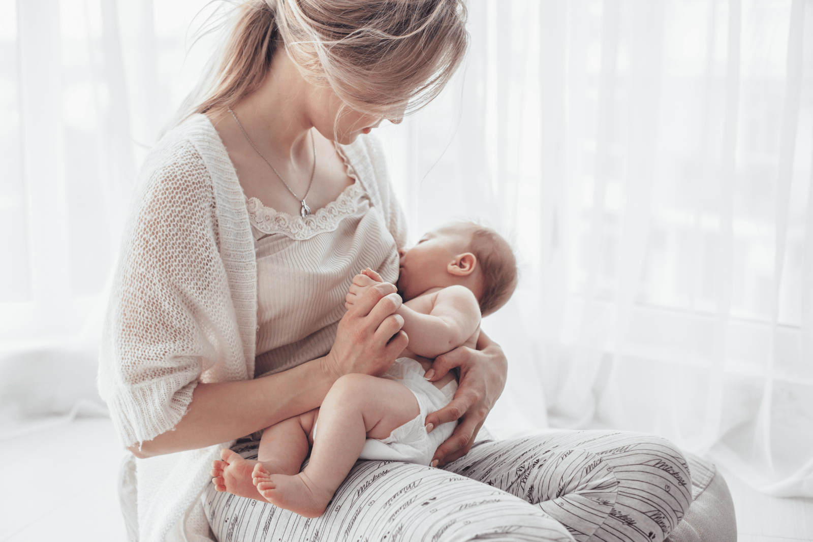  A mother breastfeeding her baby in soft natural light, holding the infant close, representing breastfeeding and maintaining a healthy milk supply.